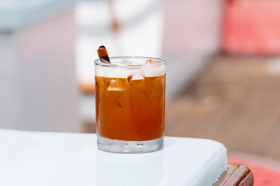 cinnamon maple whiskey sour on an outdoor white table