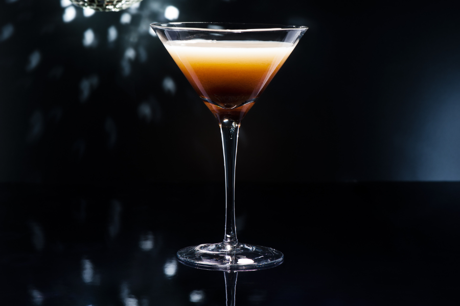 poison apple martini on a black tabletop with a dark background