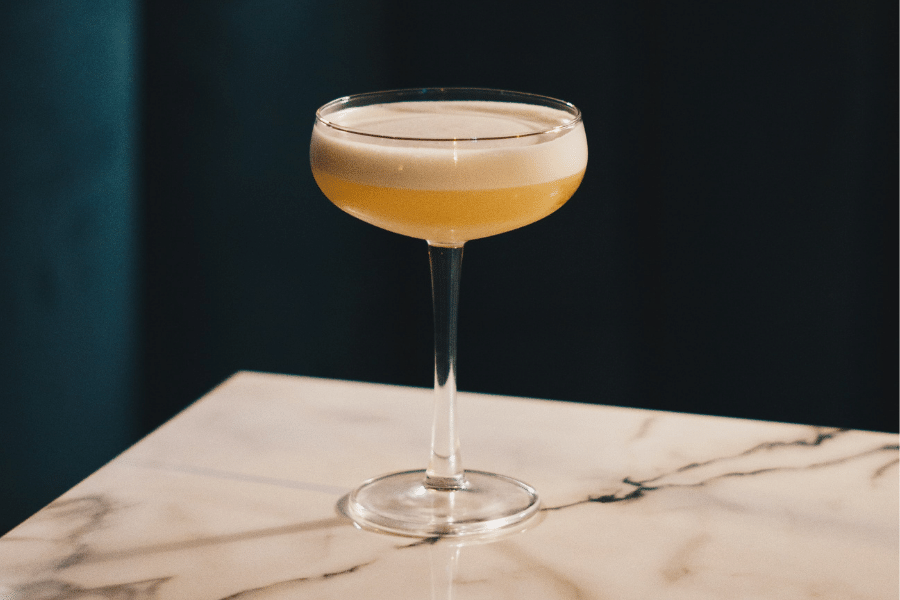 cognac sour with egg white on marble table top