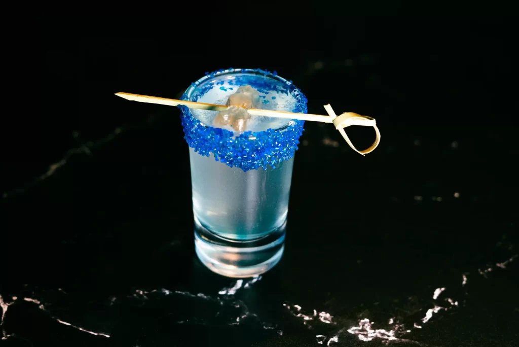 white gummy bear shot rimmed with blue sanding sugar